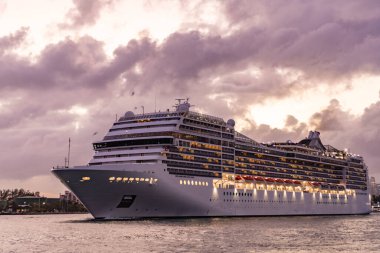 Gece vakti ışıltılı lüks yolcu gemisi yolculuğunun havadan görünüşü. Gemi Miami sahil limanından ayrılıyor. Gemi seyahati. Yaz tatilindeki deniz yolculuğunun havadan görünüşü. Gemi turu ve deniz yolculuğu..