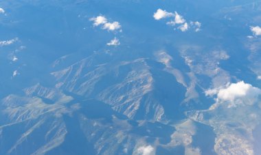 Bulut ve dağ zirvesi hava manzarası. Dağ manzarasının havadan görünüşü. Hava bulutlu görünüyor. Uçaktan manzara. Dağların tepesinde, bulutların içinde. Dağ manzaralı güzel bulutlu doğa.