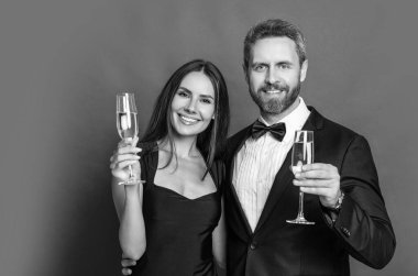 Romantik randevu kutlamaları. Sevgililer Günü. Yıldönümünü kutlayalım. Aşık çift nişanı kutluyor. Zarif çift kırmızıda izole edilmiş şampanya içer. Resmi olarak bir çift. Neşeli çift..