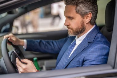 İş adamının telefonu var. Araba sigortası. Başarılı bir araba satıcısı. Satış. Takım elbiseli bir adam arabada telefon kullanıyor. Telefonu olan İspanyol bir işadamı. Başarılı bir bayilik. Araba sohbeti.