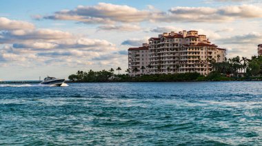 Marinaya yüzen bir tekne. Fisher Adası 'nda lüks bir yat teknesi. Yaz tatili. Fisher Adası konut binası ve lüks yat teknesi. Miami 'de Fisher Adası' na yat gezisi..