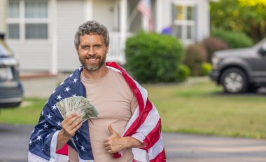 İspanyol adam ve Amerikan bayrağı. Amerika 'da vergi ödemek. Katma değer vergisi. Vergi sistemi. Vatansever adam. Amerikan bayrağı ve dolar parası olan adam. Enflasyon konsepti. Amerikan vergi politikası. Reklam..