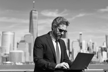 Adam internet tarayıcısından iş e-postası ve sörf yolluyor. Dijital veri yönetimi. New York 'ta serbest çalışan bir iş adamı. İnternette çalışan bir iş adamı. İş adamı dışarıda dizüstü bilgisayarla çalışıyor. Stok raporları.
