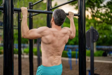 Spor barfiks egzersizi. Spor eğitimi. Sporcu adam egzersiz yapıyor. Adam kaslı sırt sporcusu açık hava spor salonunda barfiks çekiyor. Spor yaşam tarzı. Kas kasları ve trisepsler. Güçlü fiziksel atlet.