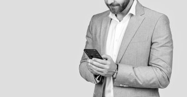 Stüdyoda erkek telefonu konuşması. Telefonu olan orta yaşlı bir İspanyol iş adamı. İş iletişimi. Gri yolda izole bir şekilde telefonda sohbet eden sıradan bir iş adamı. Telefon kullanan bir iş adamı. Pankart.