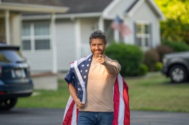 Adam Amerikan bayrağını dışarıda tutuyor. Vatanseverlik sembolü olan bir vatansever. Amerikan bağımsızlığı. Ulusal bayrak. Bağımsızlık Günü. Bağımsızlık Günü için Amerikan Bayrağı ya da 4 Temmuz. İşaret parmağı.