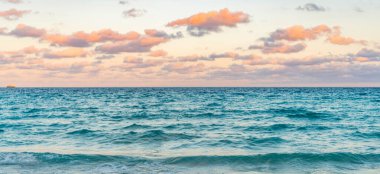 Deniz ufkuyla gökyüzü. Deniz doğarken sakin ufuk manzarası. Deniz manzarasında romantik yaz tatili gündoğumu. Deniz ufku manzarası. Yaz tatilinde bulutlu gökyüzü ve deniz manzarası. Deniz dalgaları.