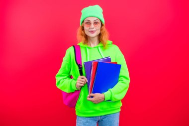 Pembe üzerine izole edilmiş bir kızın ödevi. Bilgi ve eğitim. Okul eğitimi. Modern eğitim. Kız öğrenci çalışma kitabını tutuyor. Okula dönelim. Bilgi toplama günü. Üniversitede eğitim. Resmi eğitim.