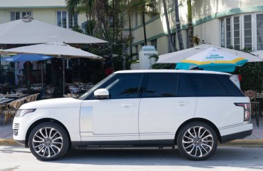 Miami, Florida, ABD - 17 Aralık 2024: Land Rover Range 2018 geçiş aracı. Land Rover 'ın lüks aracı. Beyaz araba Range Rover 'ı dışarıda park etmiş, köşe manzaralı.