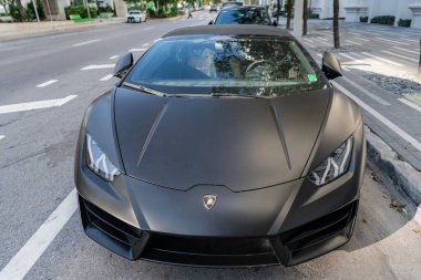 Miami, Florida, ABD - 01 Aralık 2024 Lamborghini Huracan spor araba. Lamborghini Huracan EVO 'nun siyah liman aracı. Lamborghini Huracan 'ın siyah arabası sokakta, ön manzara.