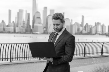 İş adamı dışarıda bilgisayar ya da dizüstü bilgisayarda çalışmakla meşgul. Adam internet tarayıcısından iş e-postası ve sörf yolluyor. New York 'ta serbest çalışan bir iş adamı. İnternette çalışan bir iş adamı. Anahtar ortaklıkları geliştir.