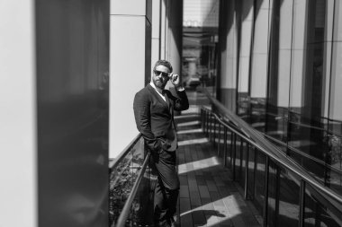 Takım elbiseli bir iş adamı. Modern cam ofisindeki iş adamı. Yakışıklı bir CEO. Başarılı bir gelecek vizyonu. Yeni fırsatlar. Ofis binasındaki iş adamı. Başarılı bir iş patronu. Reklam..
