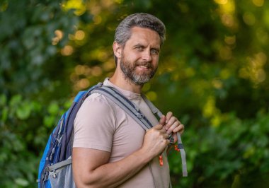 Ormanda yürüyüş yapan sırt çantalı bir yürüyüşçü. Ormanda erkek yürüyüşçü portresi. Sırt çantalı bir gezgin. Yürüyüş macerası. Seyahat yaşam tarzı. Kırsalda yürüyüş yapan bir adam. Ormandaki İspanyol adam..