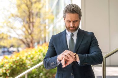 Zaman yönetimi. Dakik adam, nöbete geç kalma zamanını kontrol ediyor. Görüşmeyi bekliyorum. Dakik iş adamı dışarıda zamanı kontrol ediyor. İş için son gün. İş dünyasının son teslim tarihine geç kalan işadamı, alanı kopyala.