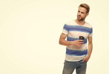 Sabahları sıcak çay içersin. Kahveyle rahatlayan bir adam. Paket kahve fincanı. Milenyum adamı bir fincan kahvenin tadını çıkarıyor. Günlük tişörtlü, elinde bir fincan kağıt kahve tutan genç bir adam. Reklam..