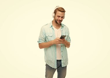 Beyazlar içinde izole edilmiş akıllı telefon uygulaması kullanan adam. Telefonla müzik dinlemek. Müzik yaşam tarzı. Ses çalma listesi. Kulaklıklı adam. Kulaklıklı adam telefondan mp3 çalma listesini seçiyor..