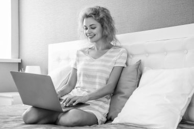 Evde dizüstü bilgisayarla çalışan pozitif kız. Serbest çalışan bir kız evde çalışıyor. Serbest çalışan biri için ev işi. Dizüstü bilgisayarı olan bir kız..