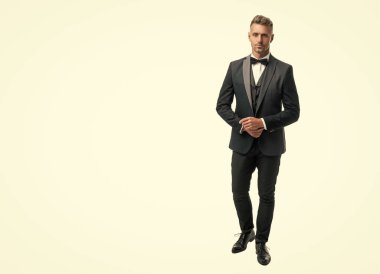 Smokinli, papyonlu olgun bir adam beyaz arka planda izole edilmiş. tam uzunluk.