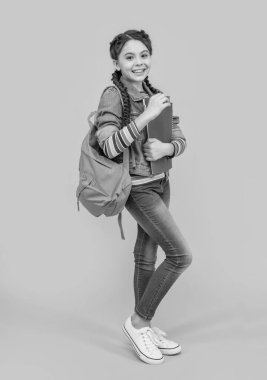 Mutlu liseli kız sarı arka planı. Okul eğitimi. Elinde kitap tutan genç bir kız, eğitim. Okul ve eğitim.