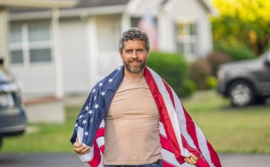 Vatanseverlik sembolü olan bir vatansever. Amerikan bağımsızlığı. Ulusal bayrak. Bağımsızlık Günü. Bağımsızlık Günü için Amerikan Bayrağı ya da 4 Temmuz. Adam Amerikan bayrağını dışarıda tutuyor. İşçi Bayramı.