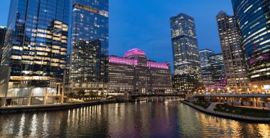 Nehirdeki Chicago gökdelenin mimarisi. Şehir gecesi aydınlatılmış bina. Gökdelen şehir manzarası. Chicago, Illinois 'de bir gece şehri. İş şehri. Chicago gökdelen binasının gece manzarası.