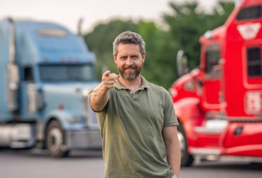 Kamyonun önünde yakışıklı bir şoför. Kamyon sahibi. Kamyon şoförü. Kamyon kamyonunun yanında bir erkek kamyon şoförü. Nakliye araçları. Yarı kamyon aracı. İspanyol kamyoncu, işaret parmağı..