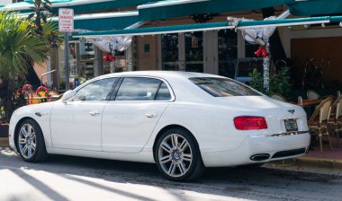 Miami, Florida, ABD - 17 Aralık 2024: 2016 Bentley Flying Spur Vur Sedan Car. Lüks araba beyaz Bentley Flying Spur V8 tipi. Bentley Uçan Mahmuz 'un arabası dışarıda park edilmiş. Bentley Uçan Mahmuz, köşe manzaralı..