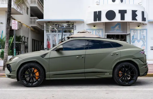 Miami, Florida, ABD - 08 Aralık 2024: Luxur yeşil renkli Lamborghini Urus S tipi spor araba. Lamborghini Urus 'un arabası dışarıda park halinde. Lamborghini Urus, yan görüş. 2024 Lamborghini Urus S SUV arabası.