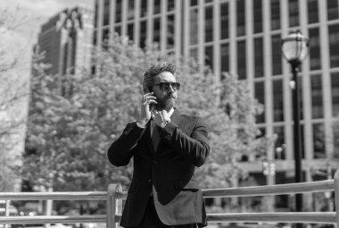 Takım elbiseli bir adam telefonda konuşuyor. Telefonu olan orta yaşlı İspanyol işadamı. İş iletişimi. İş adamının dışarıyı araması gerekiyor. Telefon kullanan bir iş adamı. Bir çağrı al..