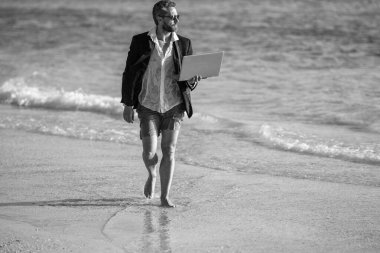 Takım elbiseli işadamı hafta sonu ve yaz tatili boyunca dizüstü bilgisayarda çalışıyor..
