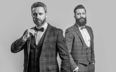 Smokinli adamlar Griler 'de izole edilmiş. Formalite icabı smokin giyen adamlar. Smokinli adamlar resmi kıyafet giyerler. Papyonlu, erkek giyimli şık erkekler. İş etkinliğindeki iki iş adamı. Resmi erkek giyim..