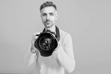 Mavide izole edilmiş erkek fotoğrafçı. Fotoğrafçı, fotoğraf makinesini tut. Profesyonel fotoğrafçılık. Çekim seansı. Fotoşop. Fotoğraf çeken bir adam. Kamerayla fotoğraf çekmek. Seçici odak.