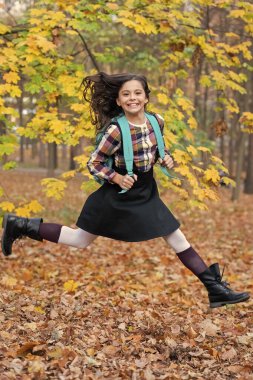 Bilgi ve eğitim. Okul eğitimi. Öğrenci hayatı. Okula dönelim. Sonbahar kızının okul çantası var. Ergenlik için eğitim. Sonbahar parkında açık havada genç bir kız. Çalışmak için sonbahar zamanı. Zıplayan öğrenci.