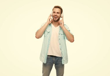 Milenyum adamı kulaklıkla müzik dinler. Müzik konsepti. Z jenerasyonu yaşam tarzı. Müzik kulaklıklarıyla ses dinleyen adam. Beyaz tenli bir adam izole edilmiş. Öğrenci çocuk sesi dinle.