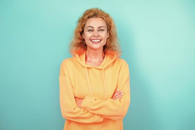 Hareketli moda kız kapüşonlu giyer. Moda kıyafetleri ve tarzı. Kazaklı beyaz bir kadın. Sıradan bir yaşam tarzı. Havalı kapüşonlu giyen kızıl saçlı kız. Maviyle izole edilmiş şık bir kadın. Kapüşonlu..