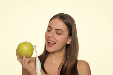 Beyaz dişler. Diş sağlığı kliniği. Elektrikli diş fırçası. Beyaz tenli dişlek kadın gülüşü. Dişlerini elektrikli diş fırçasıyla fırçalayan bir kadın. Kız dişlerini fırçalıyor..