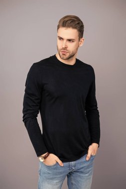 Tıraşsız adam Griler 'de izole edilmiş. Şık saç kesimi olan bir adamın portresi. Milenyum karizmatik modeli. Erkeklerin güzelliği. Kendine güveni olan adam. Gündelik kazak giyen genç yakışıklı bir adam. Kafkas modeli.