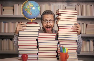 Sınıftaki kitap kurdu adam. Kitap edebiyatı öğretmeni. Okul kütüphanesinde eğitim. Adam kitap kurdu bilgi topluyor. Öğretmenler ve bilgi günü. Zeki öğretmen. Bir dahi gibi düşünüyorsun..