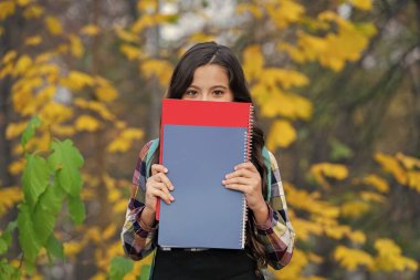 Bilgi toplama günü. Sonbahar günü. Okula dönelim. Eğitim ve bilgi. Okul eğitimi. Öğrenci kız sonbaharda ödev yapar. Çalışmak için sonbahar zamanı. Liseli kız dışarıda bilgi topluyor. Sınava hazırlanın..