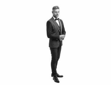 Beyaz arka planda boyun yayı olan takım elbiseli hırslı bir iş adamı. tam uzunluk.