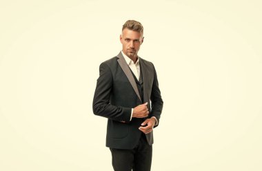 Resmi smokinli, kır saçlı bir iş adamı beyazlar içinde izole edilmiş..