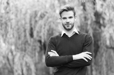 Gündelik tarzda giyinen yakışıklı genç adam dışarıda ellerini çapraz yaptı. Boşluğu kopyala.