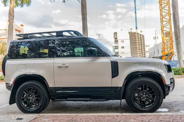 Miami, Florida, ABD - 08 Aralık 2024: 2023 Land Rover Defender SUV pikap kamyonu. Land Rover Defender 'ın lüks SUV arabası. Land Rover 'ın arabası dışarıda park edilmiş. Land Rover Defender, yan görünüm.