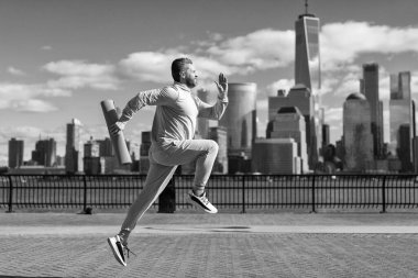 Spor antrenmanında koşan koşucu. Sporcu koşucu ya da koşucu. Spor takım elbiseli bir adam koşu yapıyor. Manhattan 'da koşan adam. New York 'ta sabah sporu koşucusu. Hafta sonları spor.