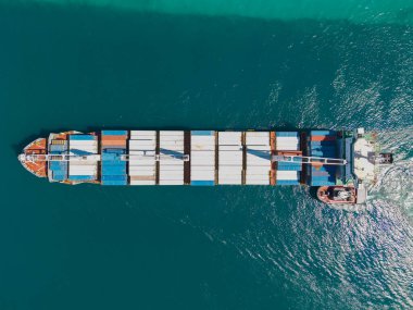 Konteyner gemisi. İhraç ve ithalat. Kargo işi. Nakliye lojistiği. Konteynırlı kargo gemisi, hava manzaralı. Kargo gemisinde nakliye konteynırı. Kargo gemisi limandan ayrılıyor. Ticari gemi.