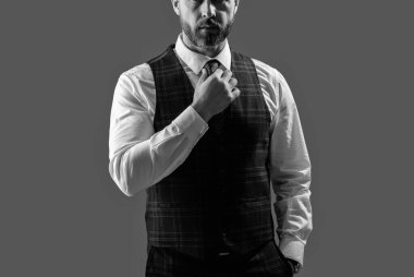 Erkek giyim kuşamı. Bespoke takımı. Resmi erkek giyim konsepti. Formalite icabı iş adamı. Kesik manzaralı. Zarif terzilik yeleği giymiş bir iş adamı. Gri kravatlı resmi takım elbise. Resmi Duruşma.