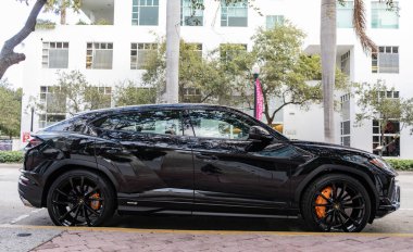Miami, Florida, ABD - 08 Aralık 2024 Lamborghini Urus S SUV spor yara izi. Lamborghini Urus S tipi lüks bir spor araba. Lamborghini Urus 'un arabası dışarıda park edilmiş. Siyah Lamborghini Urus, yan görünüm.