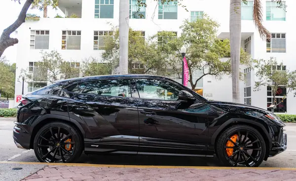 Miami, Florida, ABD - 08 Aralık 2024 Lamborghini Urus S SUV spor yara izi. Lamborghini Urus S tipi lüks bir spor araba. Lamborghini Urus 'un arabası dışarıda park edilmiş. Siyah Lamborghini Urus, yan görünüm.