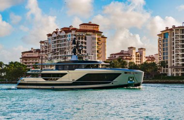 Marinaya yüzen bir tekne. Fisher Adası 'nda lüks bir yat teknesi. Yaz tatili. Fisher Adası konut binası ve lüks yat teknesi. Miami Fisher Adası Panorama Manzarası.