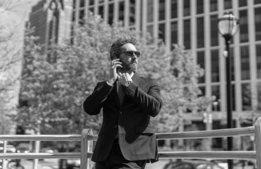 Telefonu olan orta yaşlı İspanyol işadamı. İş iletişimi. İş adamının dışarıyı araması gerekiyor. Telefon kullanan bir iş adamı. Takım elbiseli bir adam telefonda konuşuyor. Mesleki görgü kuralları.